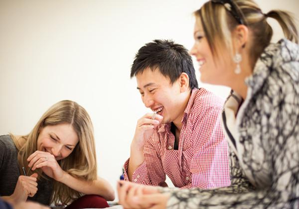 Three people working at a table together. 