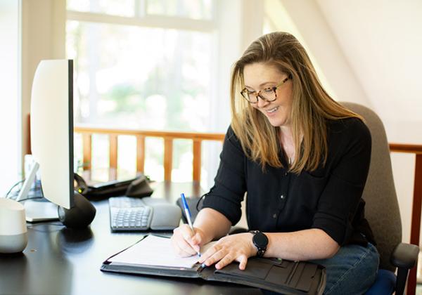 Happy woman at a desk writing