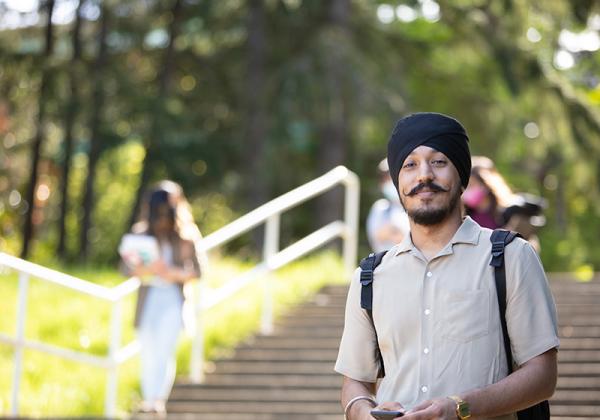 Young man in a turban on a staircase outdoors. 