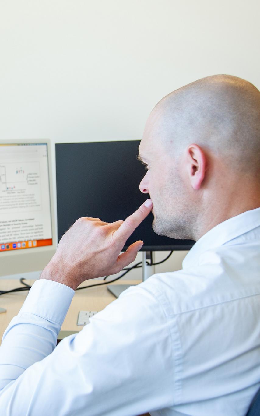 A man looking at two computer screens